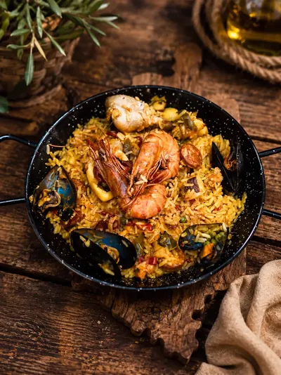 Paella royale servie dans sa poêle : gambas, moules et poulet, restaurant A Pergola à Porto-Vecchio