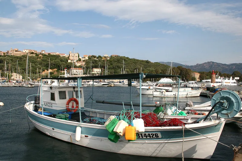 Bateaux amarrés dans la marina de Porto-Vecchio, bâtiments et collines en arrière-plan